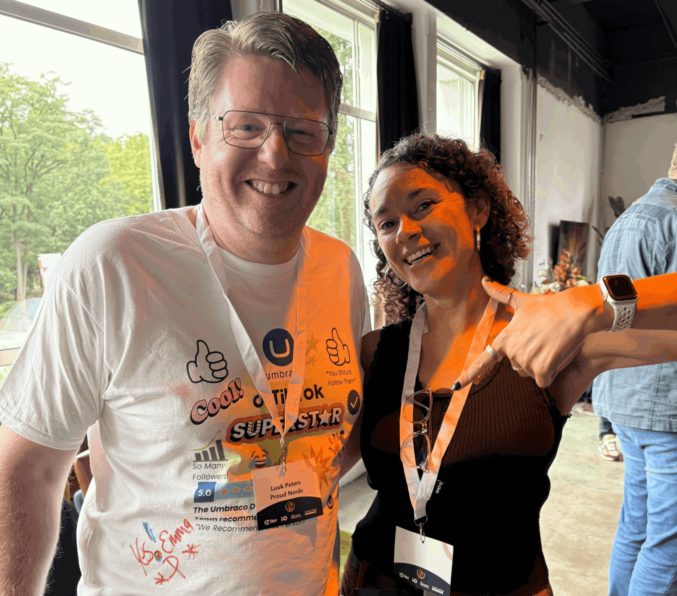 A photo of Luuk and Emma smiling and standing in front of a window